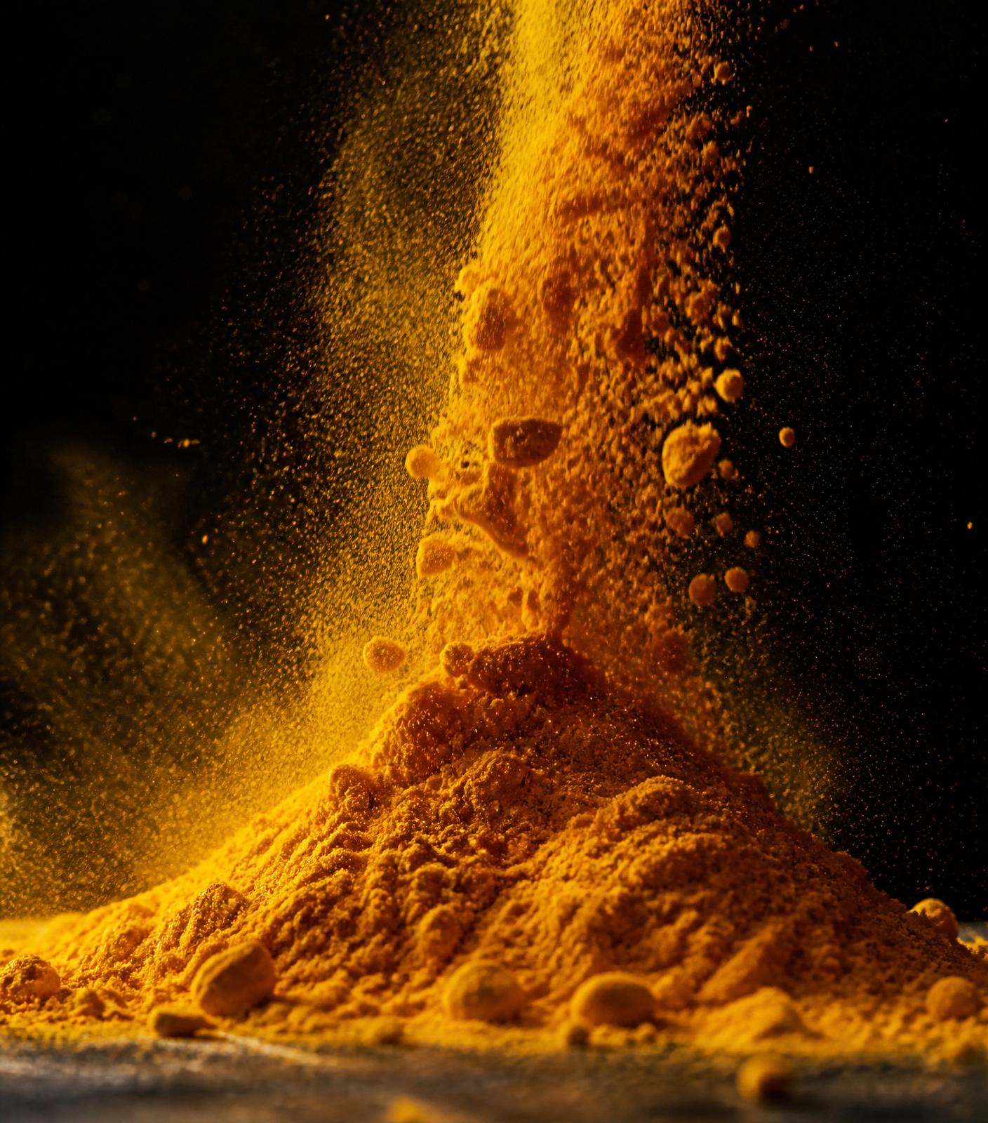 Ground spice being poured into a kraft pouch